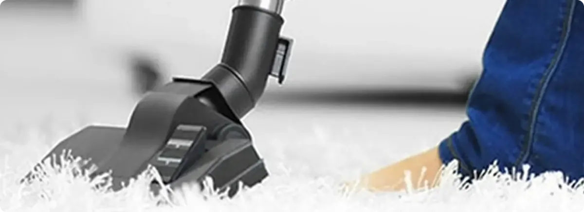 Close-up of a professional vacuuming a white carpet in Hilliard.